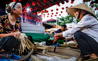 Craftspeople making incense sticks at a market in Hanoi's Incense Village.