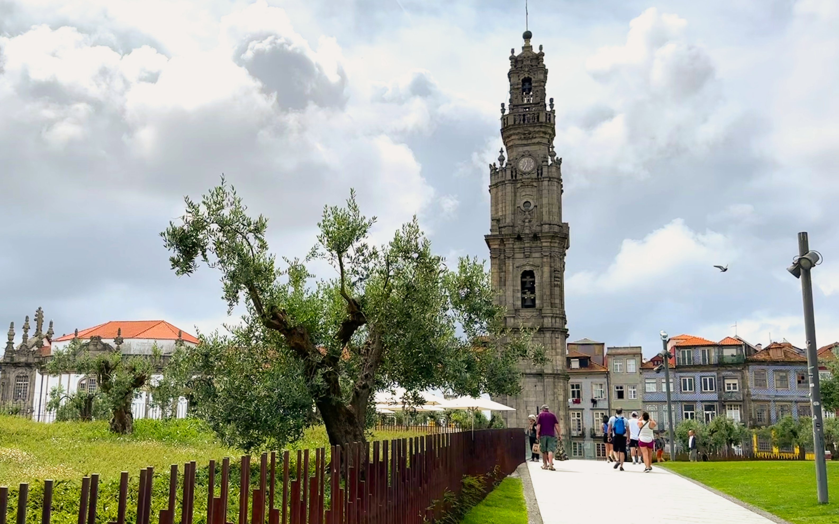 Clérigos Church tower in Porto with people walking nearby.