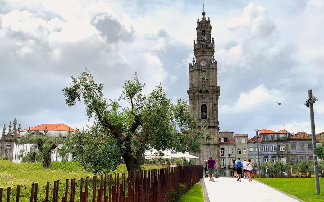 Clérigos Church tower in Porto with people walking nearby.