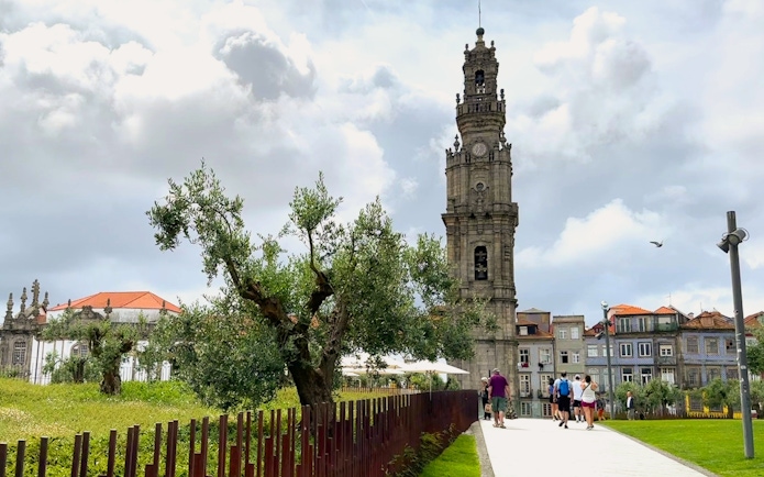 Clérigos Church tower in Porto with people walking nearby.