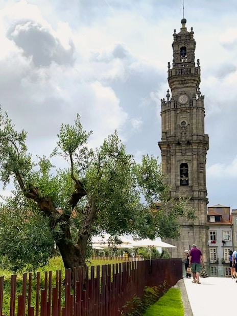Clérigos Church tower in Porto with people walking nearby.