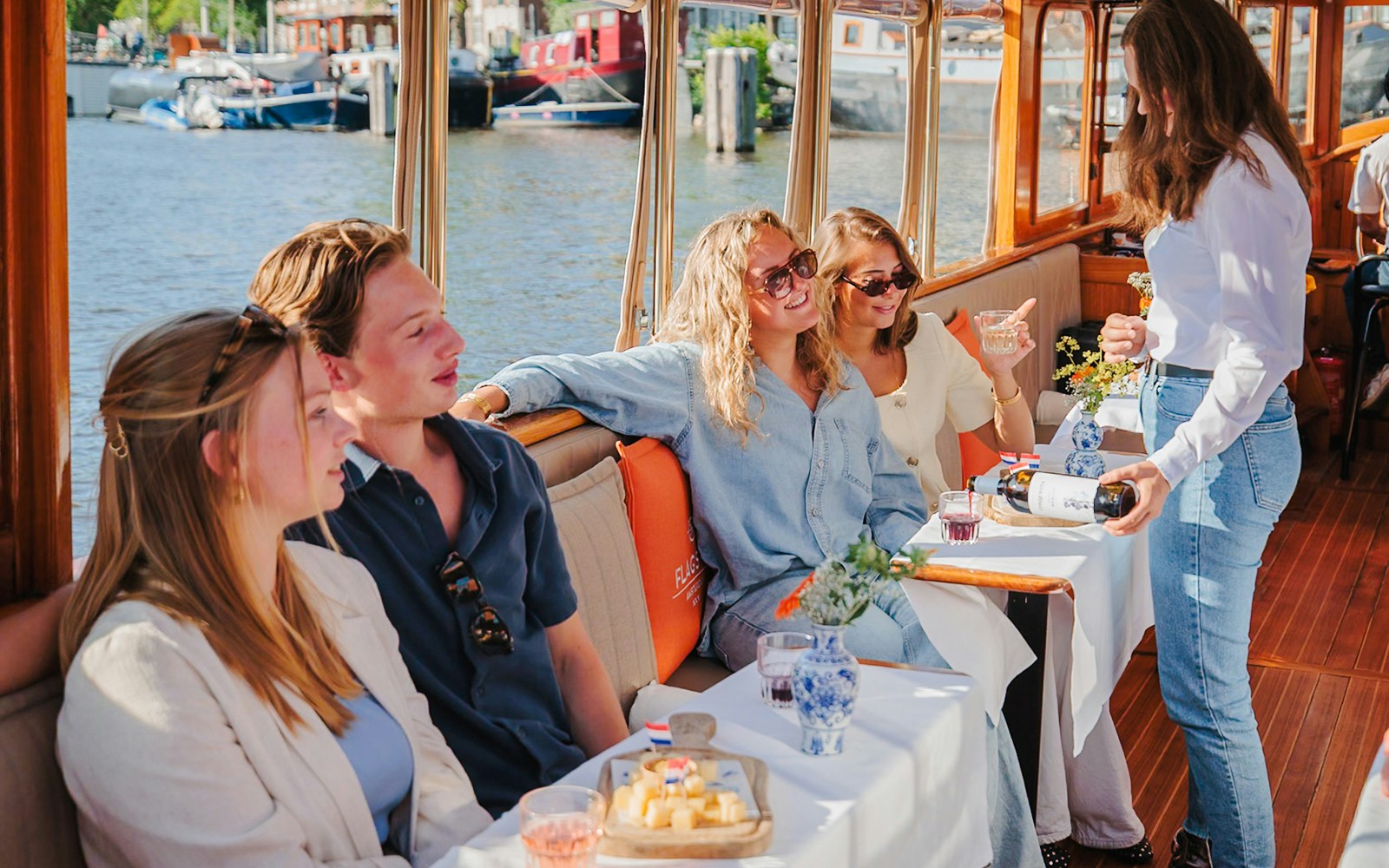 Guests enjoying cheese and wine on a canal cruise in Amsterdam.