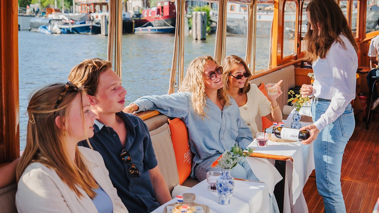 Guests enjoying cheese and wine on a canal cruise in Amsterdam.