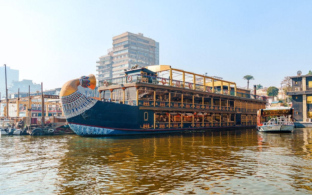 Nile cruise ship with pharaoh-themed decor docked in Cairo, Egypt.