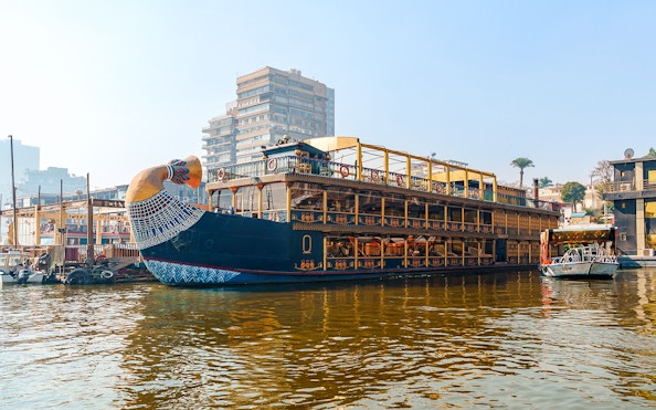 Nile cruise ship with pharaoh-themed decor docked in Cairo, Egypt.