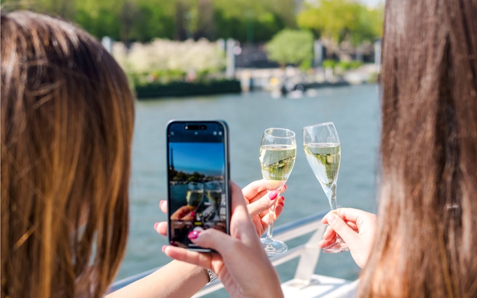 Two people toasting with champagne on a Seine River cruise in the evening.