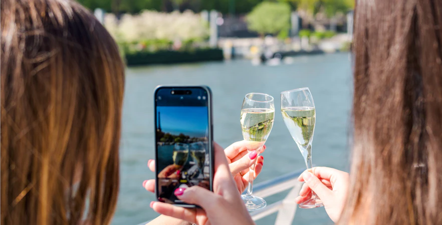 Two people toasting with champagne on a Seine River cruise in the evening.