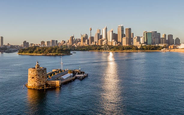 Sydney Harbour with Fort Denison and city skyline in the background, viewed from the water.