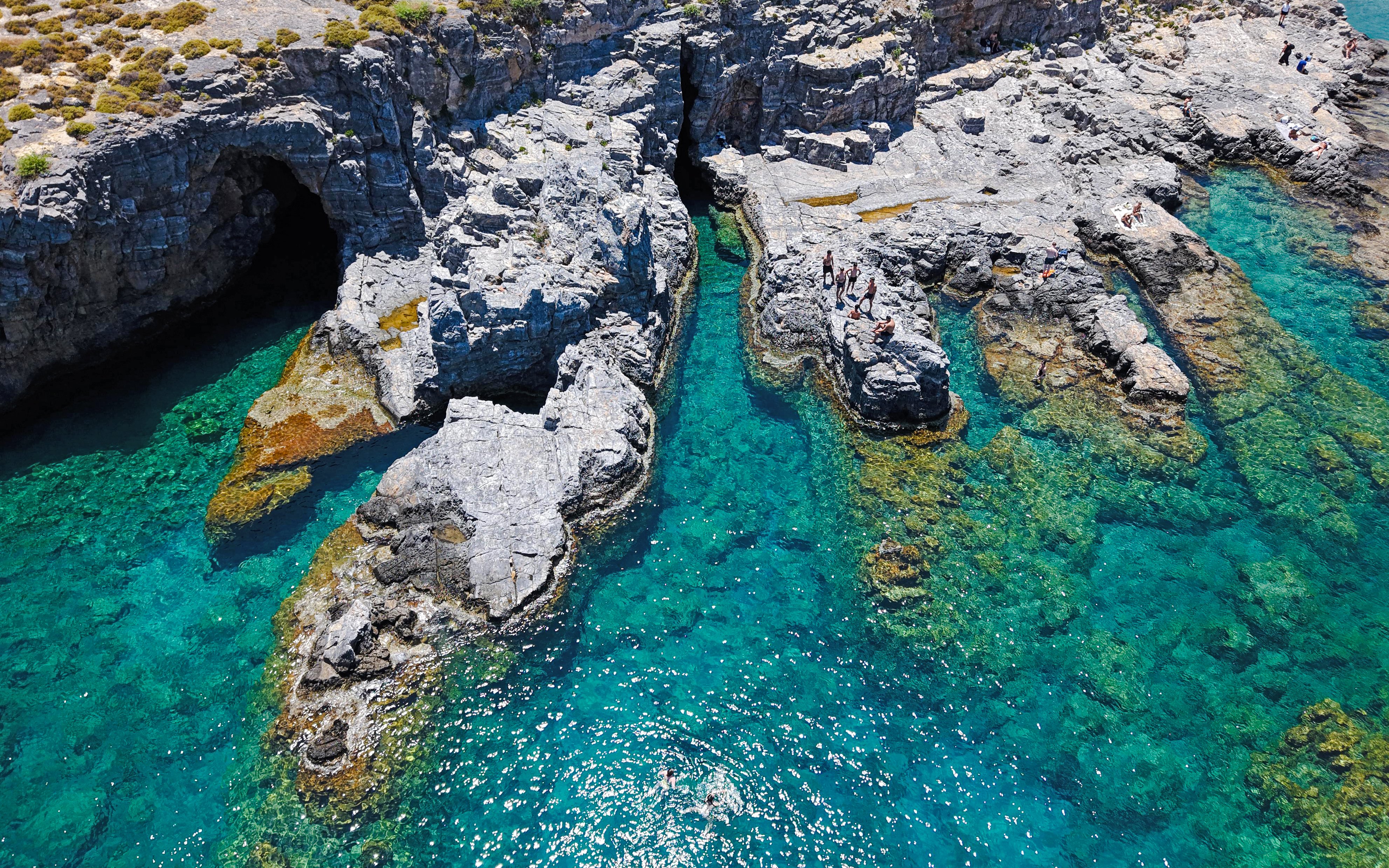 Cliffs and clear turquoise waters at Lindos Bay, Greece.