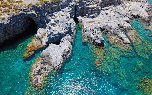 Cliffs and clear turquoise waters at Lindos Bay, Greece.