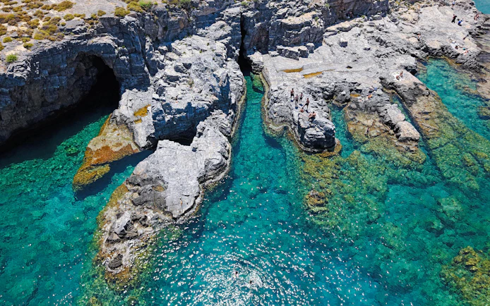 Cliffs and clear turquoise waters at Lindos Bay, Greece.