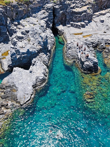 Cliffs and clear turquoise waters at Lindos Bay, Greece.