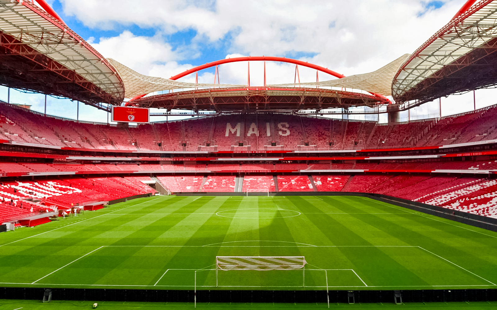 Benfica Stadium in Lisbon, Portugal, empty with green field and red seating.