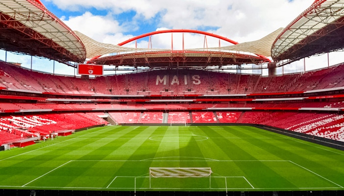 Benfica Stadium in Lisbon, Portugal, empty with green field and red seating.