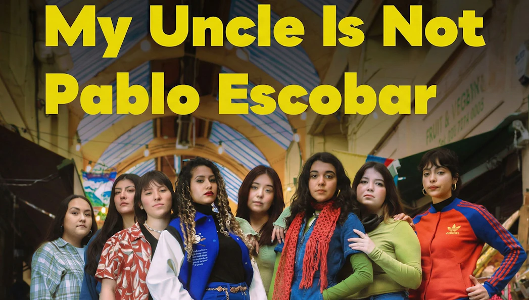 Group of women standing under a market roof, promoting "My Uncle Is Not Pablo Escobar" West End show.