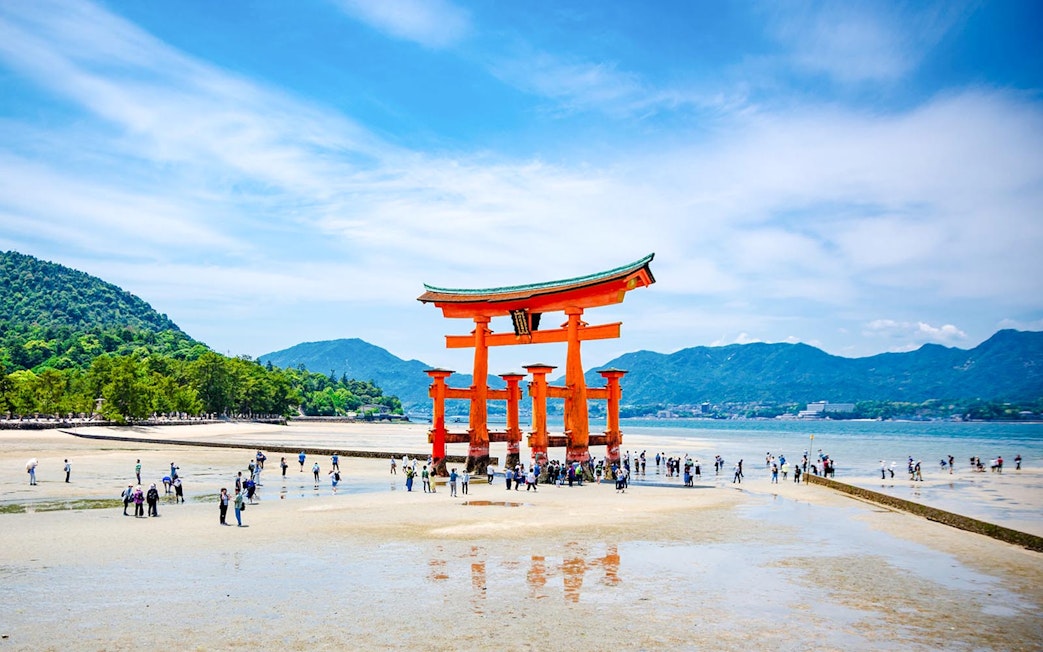 Iconic floating torii gate of Itsukushima Shrine with visitors, Miyajima Island, Japan.