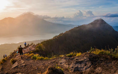 Hikers on Mount Batur trail with sunrise view in Bali, Indonesia.