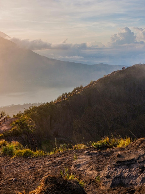 Hikers on Mount Batur trail with sunrise view in Bali, Indonesia.