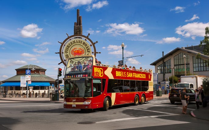 Big Bus tour at Fisherman's Wharf, San Francisco, with iconic sign in background.