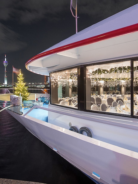 Cruise ship decorated for Christmas on the Rhine River, Düsseldorf at night.