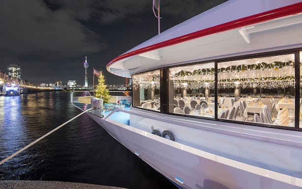 Cruise ship decorated for Christmas on the Rhine River, Düsseldorf at night.