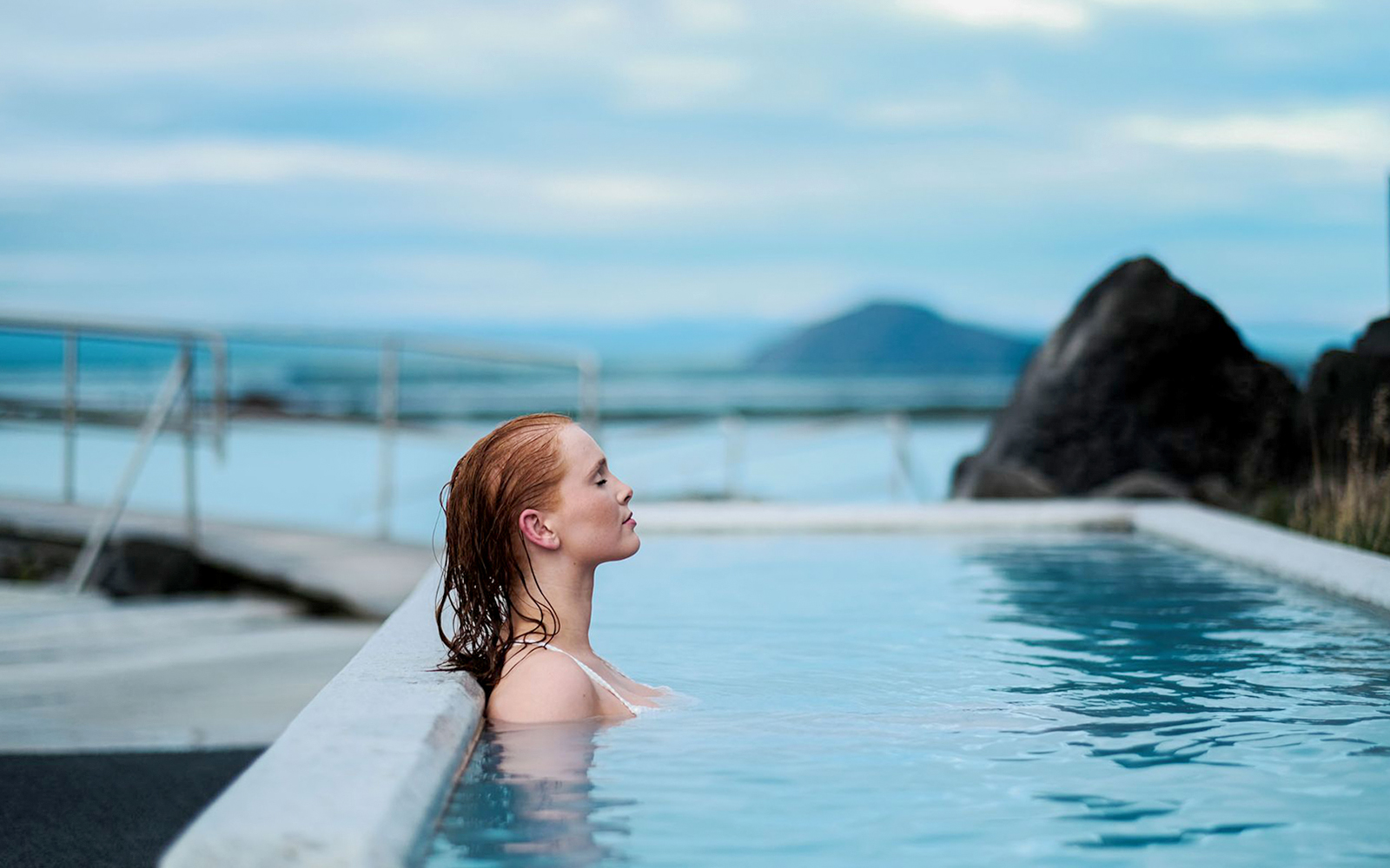 Guest relaxing in geothermal pool at Myvatn Nature Baths, Iceland.