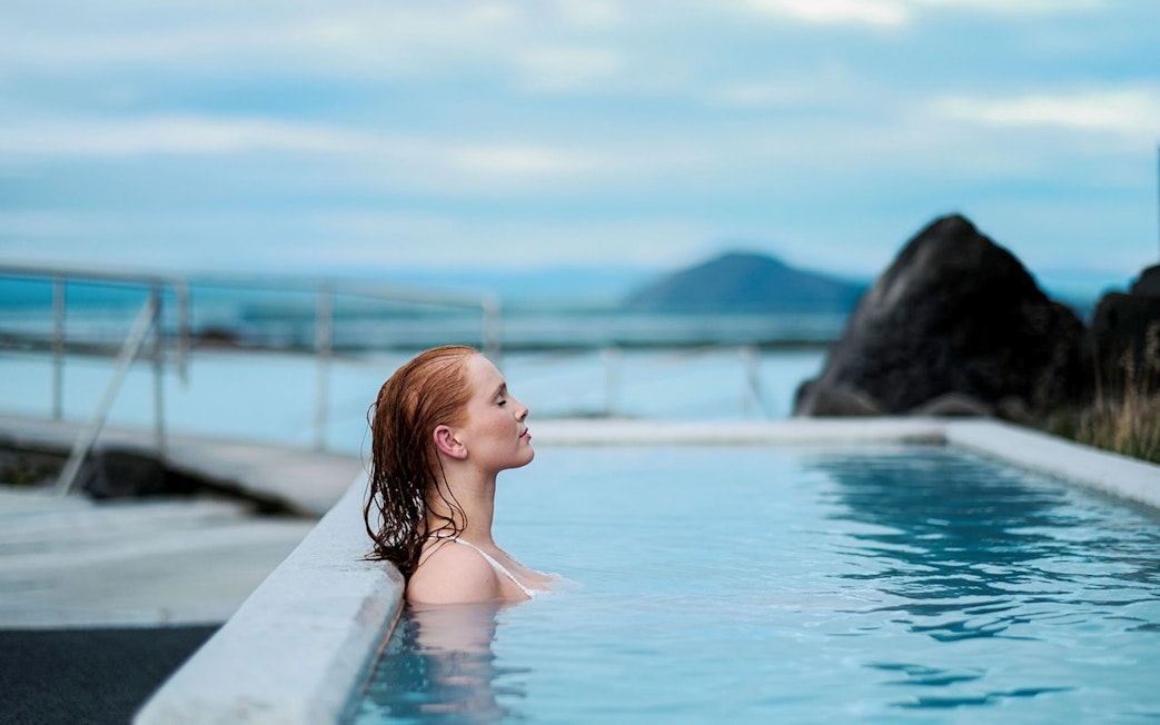 Guest relaxing in geothermal pool at Myvatn Nature Baths, Iceland.