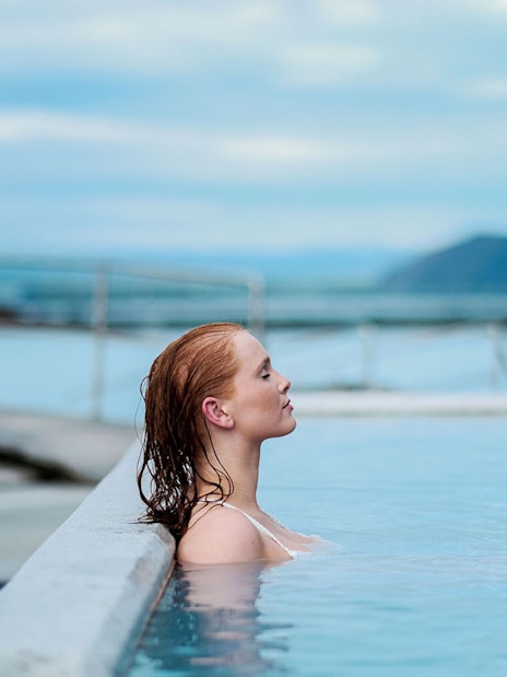 Guest relaxing in geothermal pool at Myvatn Nature Baths, Iceland.