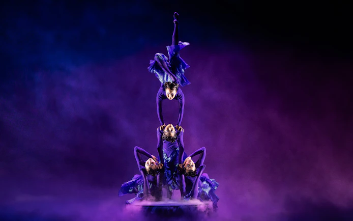 Acrobats performing a balancing act in Cirque du Soleil Alizé show.