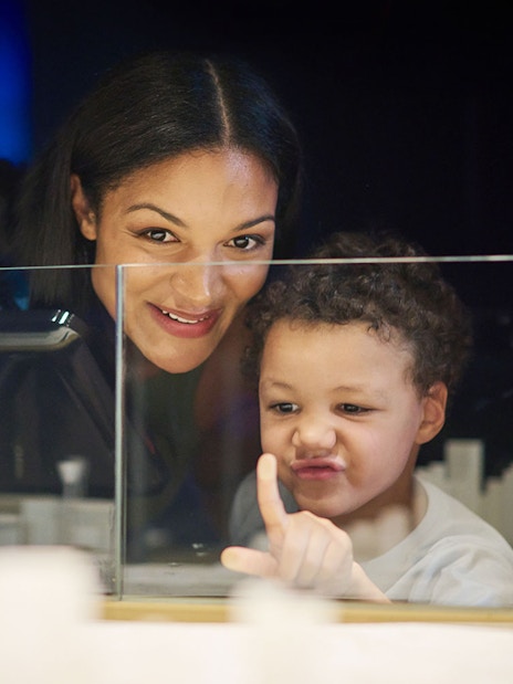 Child and adult exploring Melbourne Skydeck model during Ultimate Skydeck Experience.
