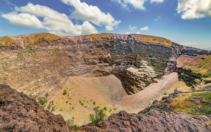 Mount Vesuvius crater with rocky terrain and clear sky in Naples, Italy.