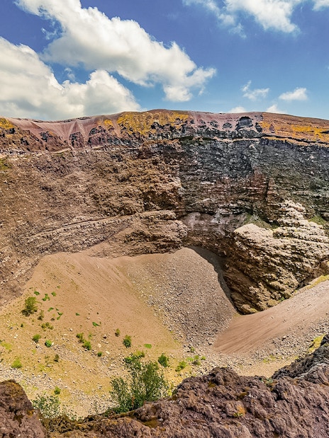 Mount Vesuvius crater with rocky terrain and clear sky in Naples, Italy.