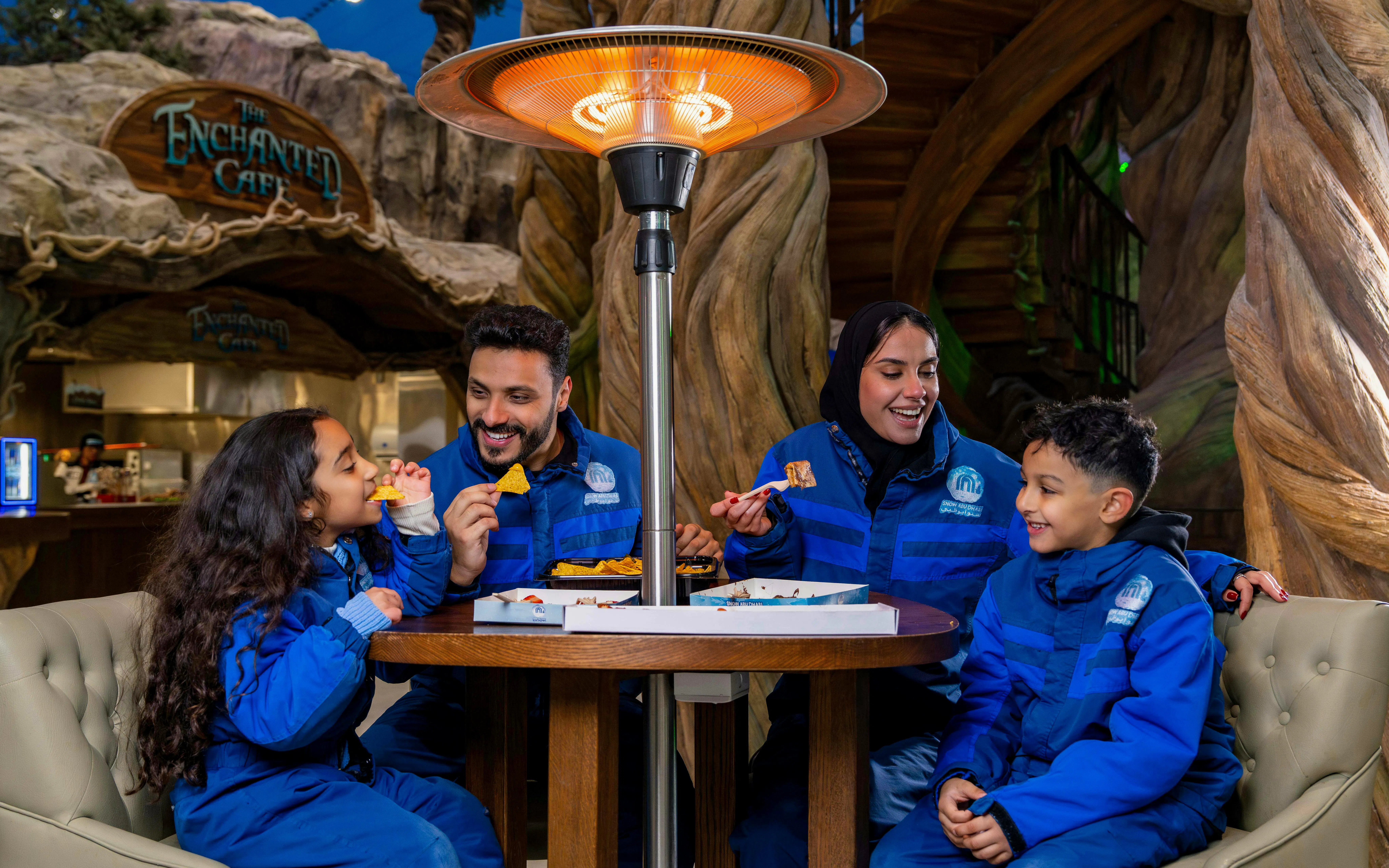 Family enjoying snacks at Enchanted Cafe, Snow Abu Dhabi.