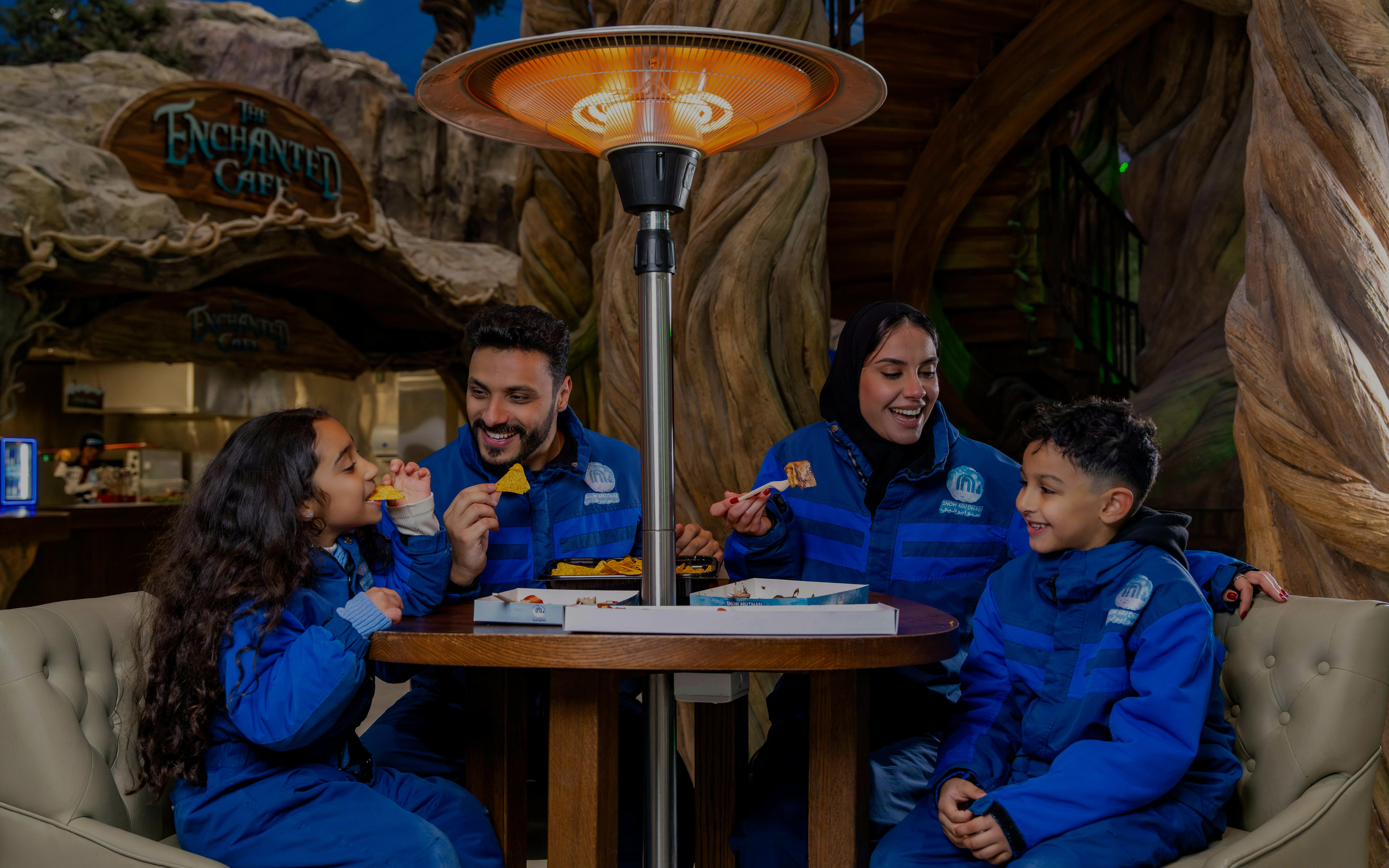 Family enjoying snacks at Enchanted Cafe, Snow Abu Dhabi.