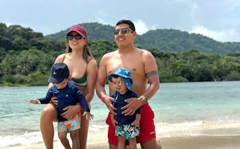 Family enjoying Isla Mamey beach with lush hills in the background, Panama City tour.