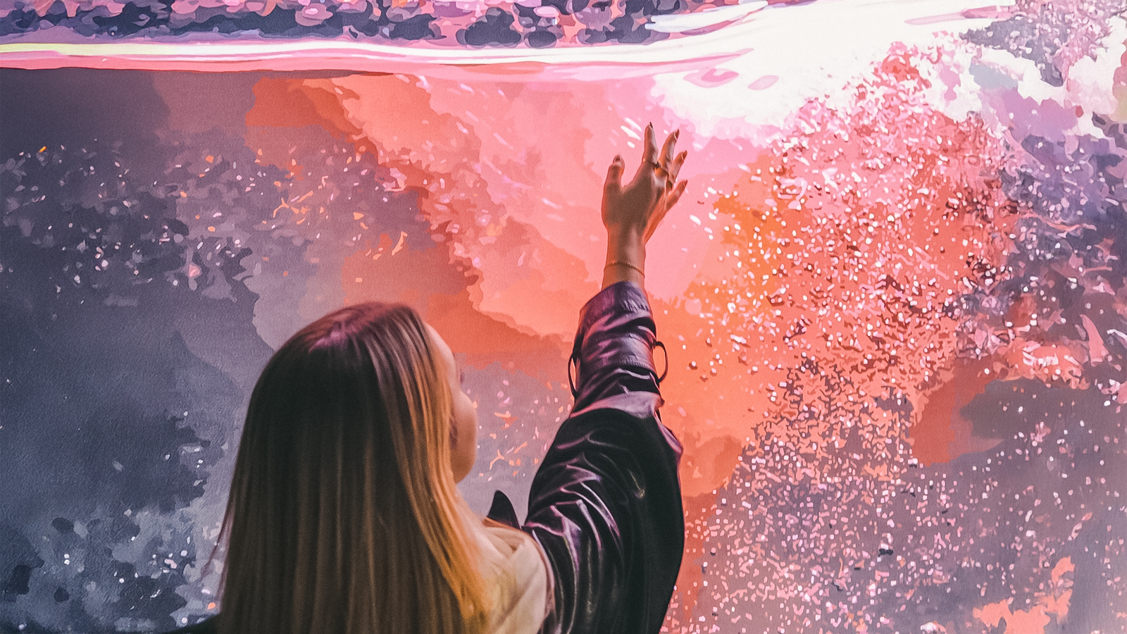 Person reaching towards vibrant abstract art at The Wine Experience.