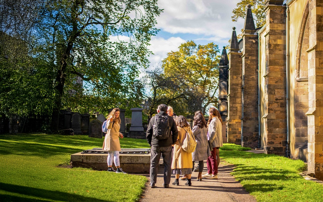 Group on a guided Harry Potter walking tour in a historic cemetery.
