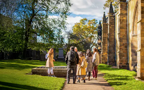 Group on a guided Harry Potter walking tour in a historic cemetery.