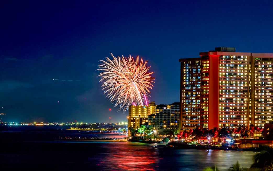 Fireworks over Waikiki beach with city skyline, Hawaii.