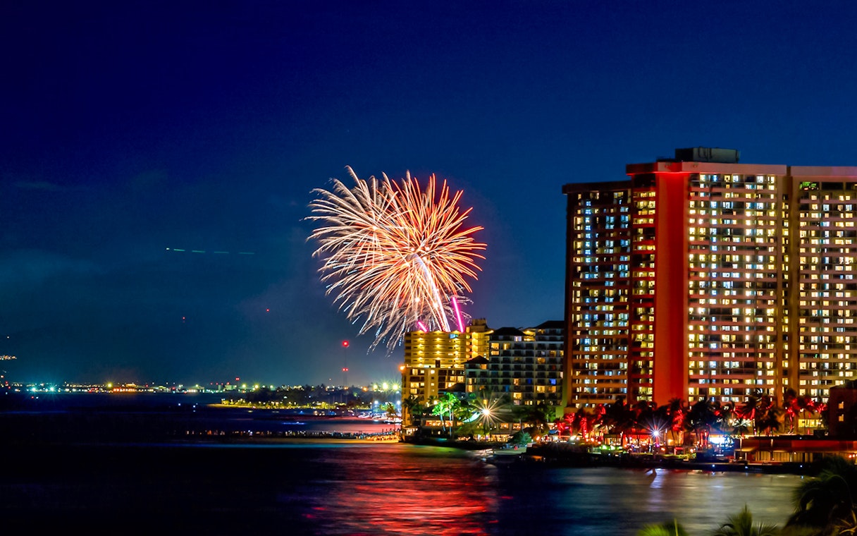 Fireworks over Waikiki beach with city skyline, Hawaii.