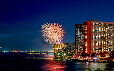 Fireworks over Waikiki beach with city skyline, Hawaii.