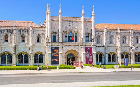 Exterior view of the Maritime Museum in Lisbon with visitors walking outside.