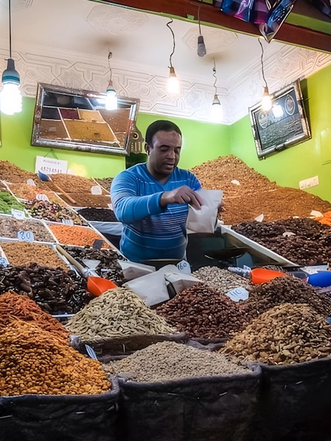 Vendor selling spices at a Marrakech market during a night walking tour.