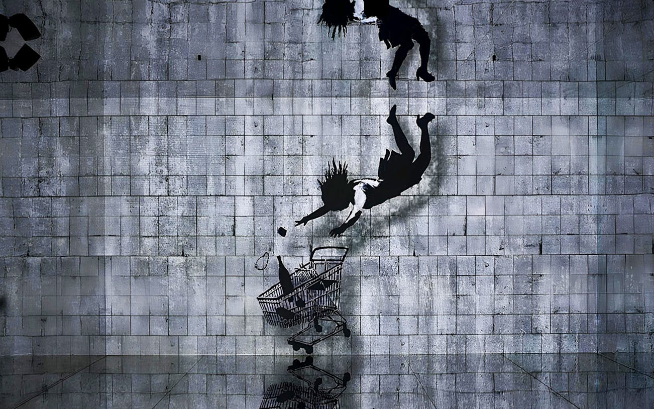 Street art mural by Banksy depicting a figure falling towards a shopping cart.