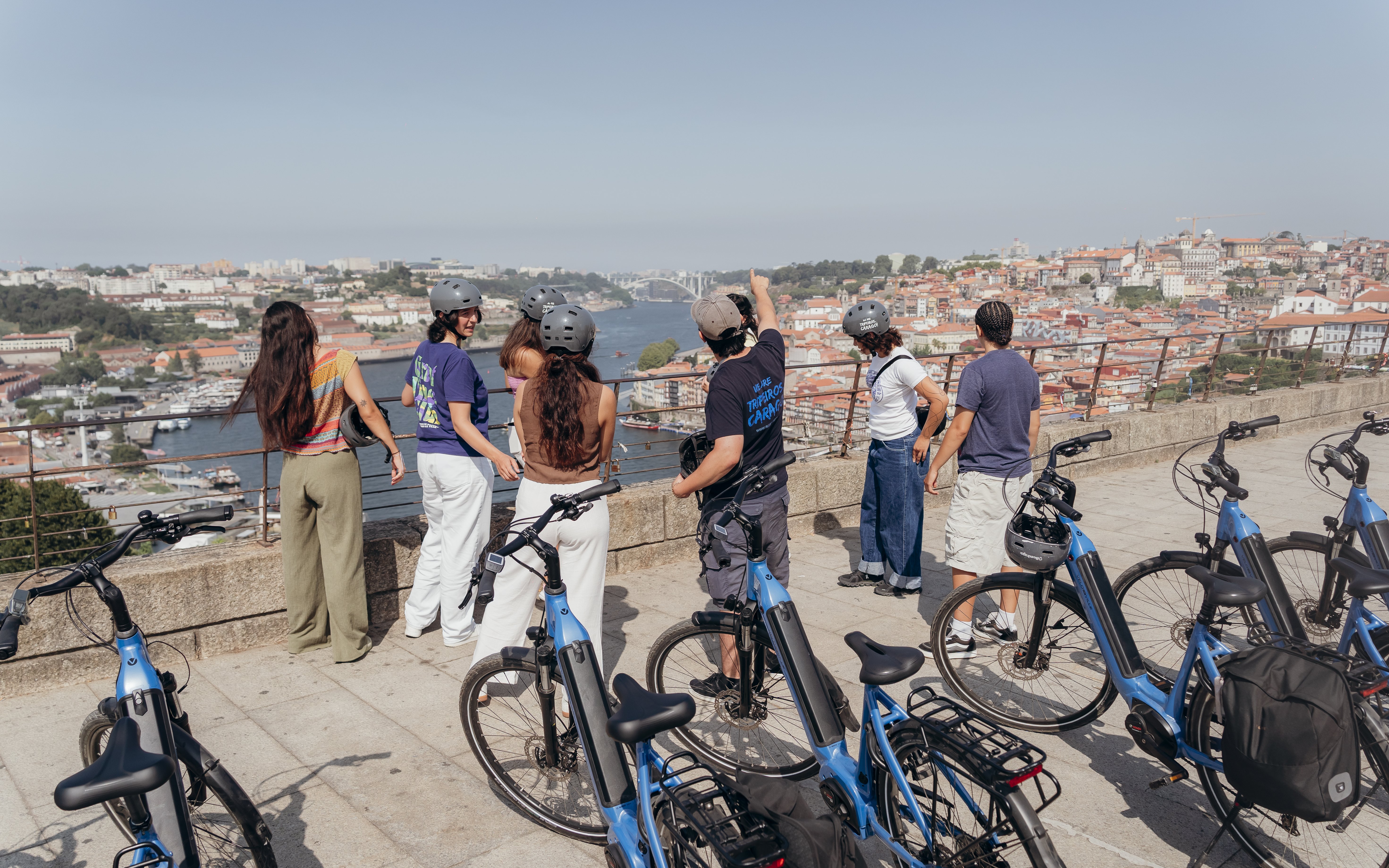 Tourists with guide overlooking Porto on electric bike tour.