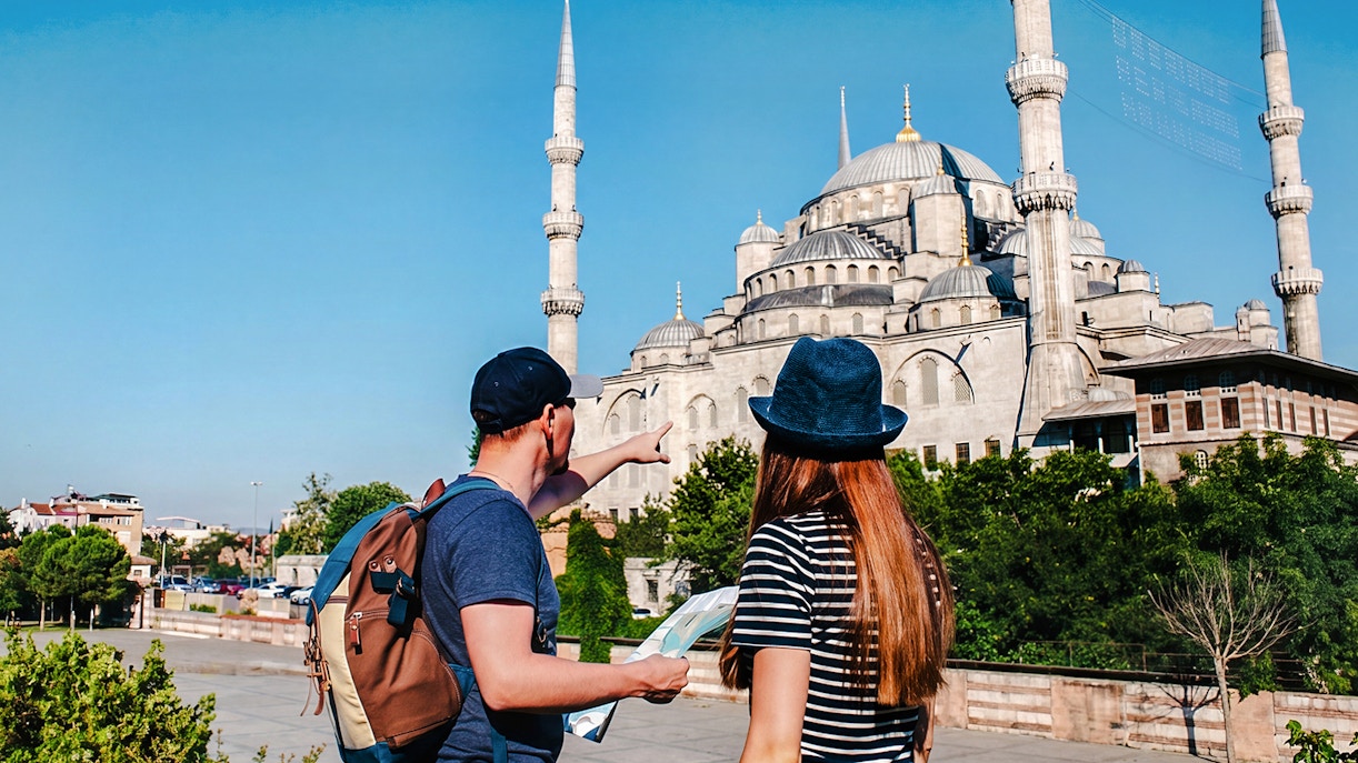 Guide and tourist with map near Blue Mosque, Istanbul.