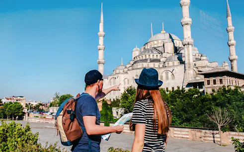 Guide and tourist with map near Blue Mosque, Istanbul.