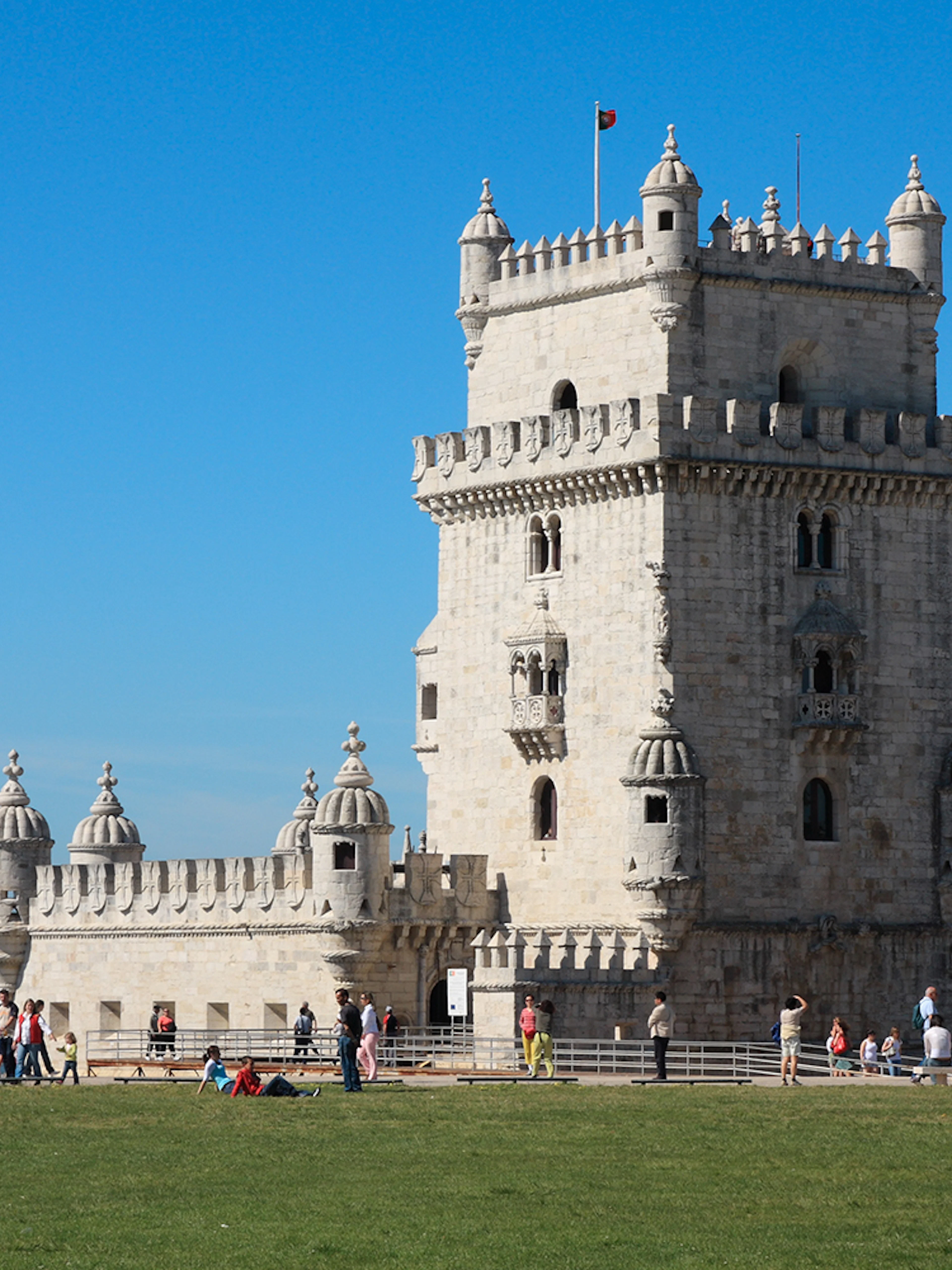Belém Tower exterior with visitors in Lisbon, Portugal.