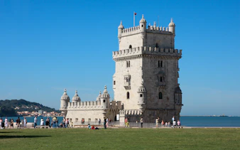 Belém Tower exterior with visitors in Lisbon, Portugal.