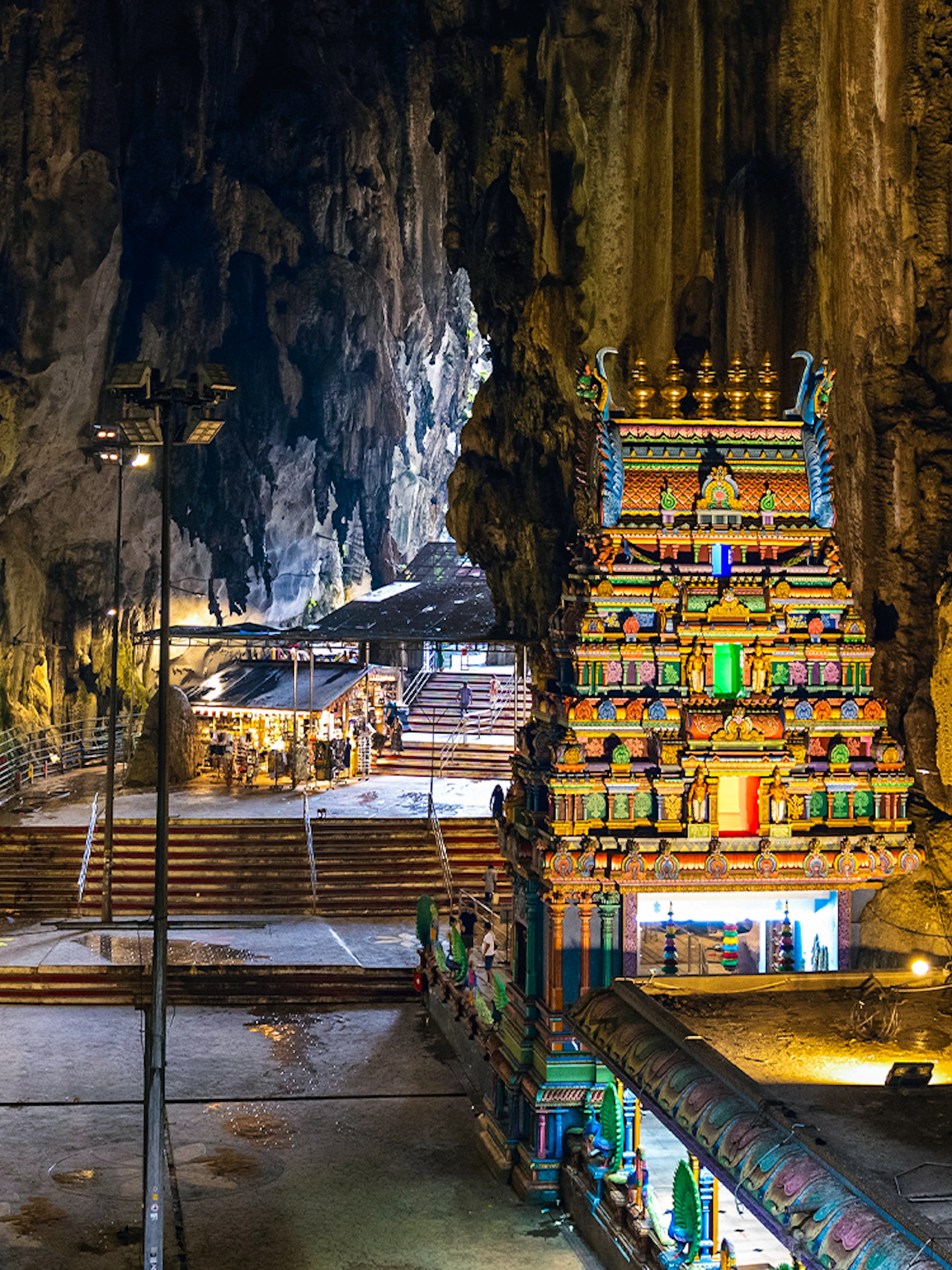 Hindu temple inside Batu Caves with colorful facade and rocky cave walls.